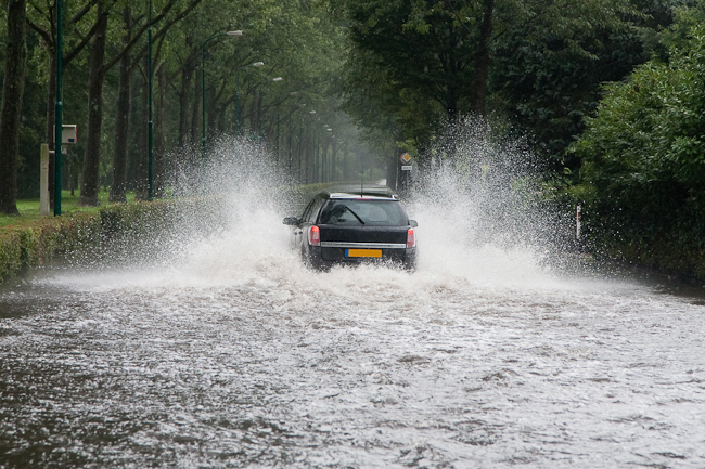 Car driving through a flooded street