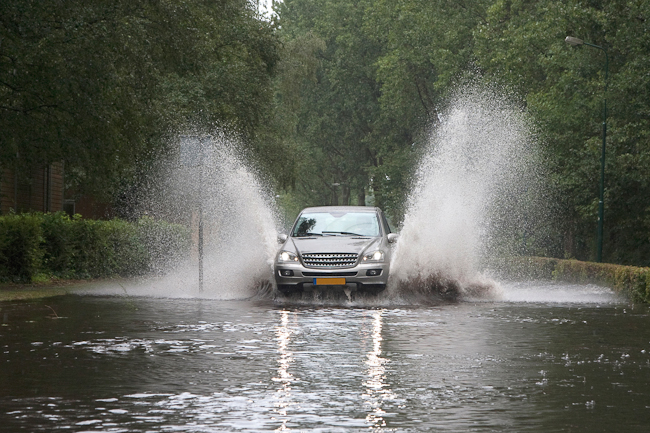 Car driving through a flooded street